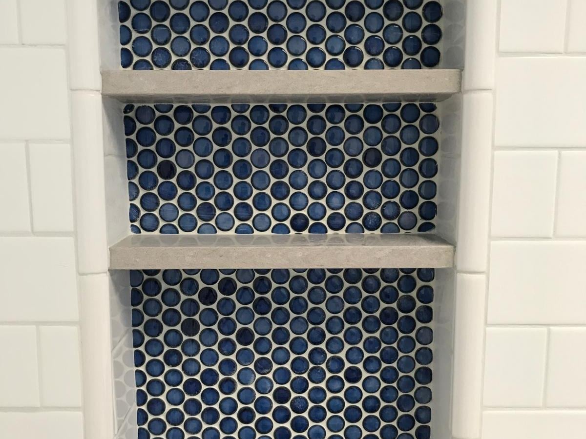 Shower Niche. Recessed niche with blue penny tile and stone shelves.